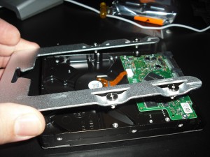 DSCF0016 Position the carrier over the hard drive; be careful not to drag the attached screws across the circuitry on the drive.
